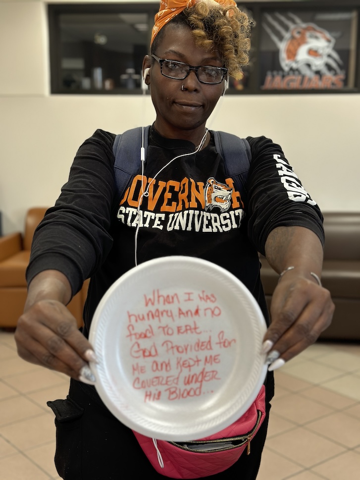 Person holding plate with message written on it